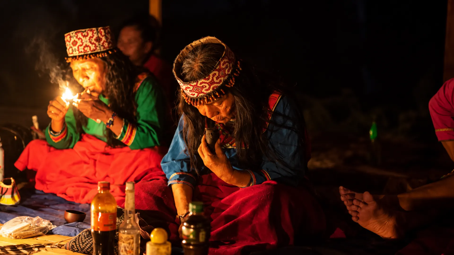 Curanderas preparando la ceremonia de noche a la luz de una llama